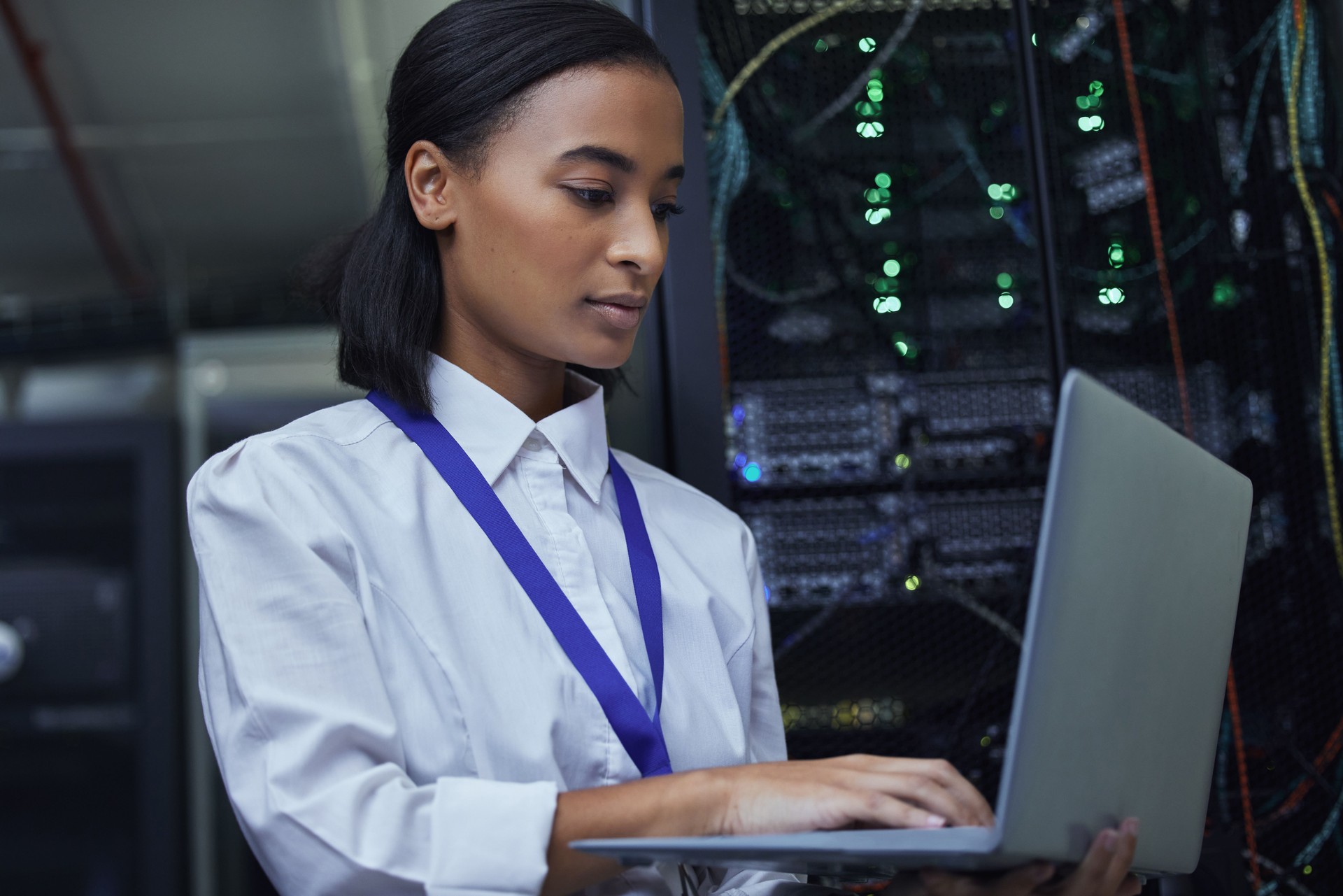 Cropped shot of an attractive female IT support agent working in a dark network server room